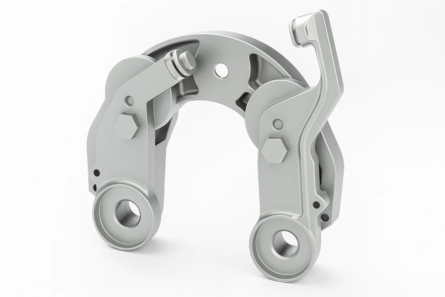 Close-up view of a silver precision brake caliper assembly with smooth machined surfaces and mounting holes.