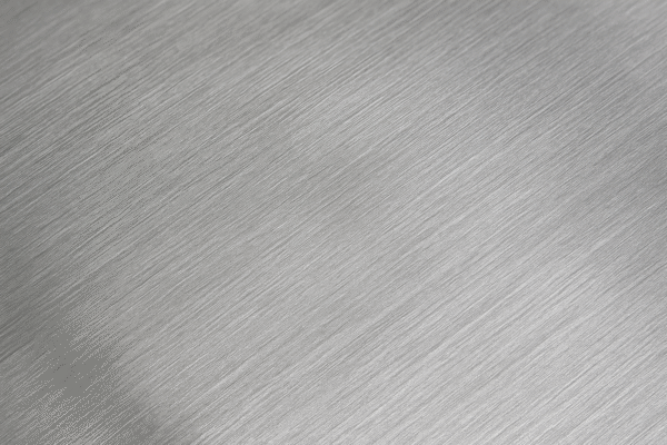 Close-up of a brushed stainless steel surface with a passivated finish, showing fine diagonal grooves and a soft matte sheen.