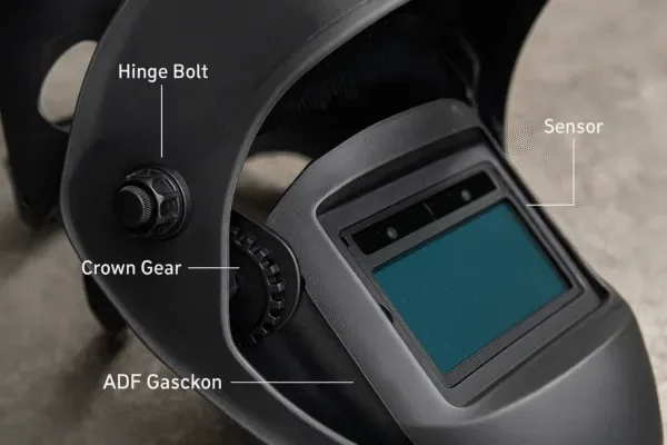 Welding helmet inspection points showing hinge bolt, crown gear, ADF gasket, and sensor area for routine safety maintenance checks.