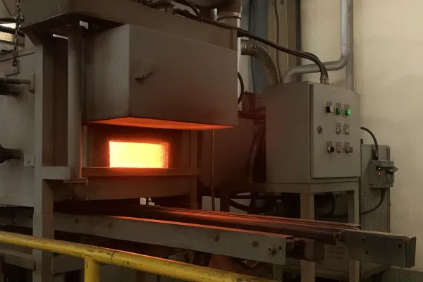 Industrial furnace with glowing heat, used for metal heating and processing in manufacturing.