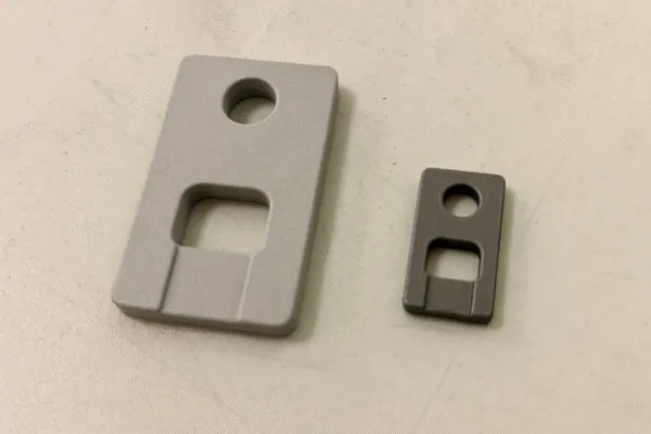 Close-up of two metal parts of different sizes, showcasing precise machining and surface finish differences.