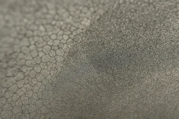 Close-up of a textured surface with a honeycomb pattern on a metal part.