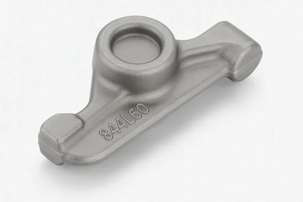 Cast iron rocker arm with a matte gray finish, featuring a central rounded cavity and clearly embossed part number, presented on a white surface with soft shadows.