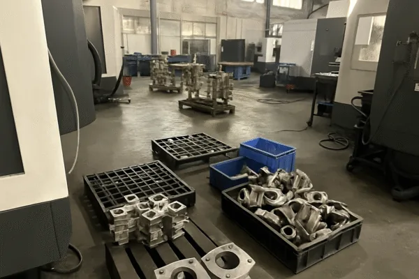 CNC machining workshop with trays of precision machined metal parts on the factory floor, ready for inspection and packing.