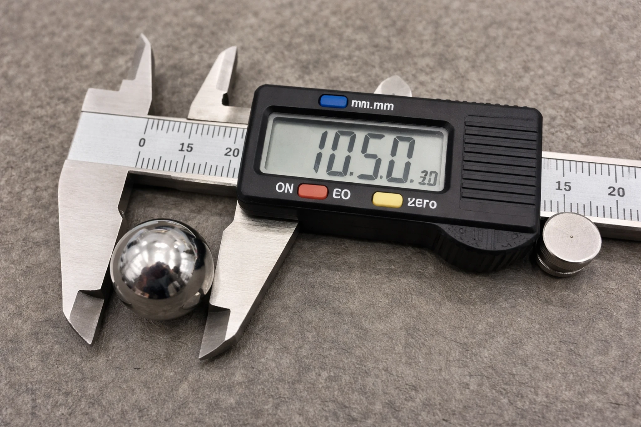 High-resolution image of a digital caliper measuring the diameter of a polished metal ball, with the LCD display showing 10.50 mm.
